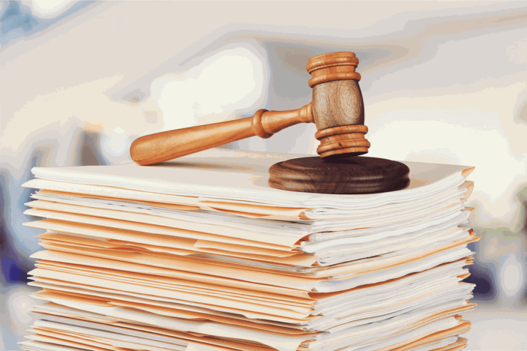 Judge gavel resting on stack of legal documents symbolizing law, justice, and court cases.