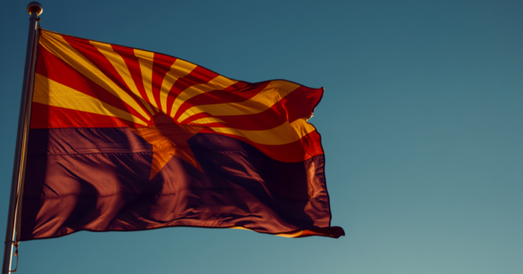 Arizona flag rippling against a clear blue sky